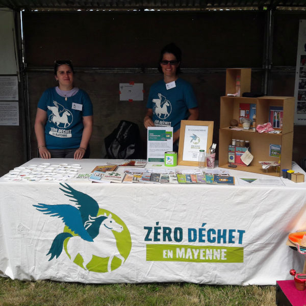 Photo du stand avec deux bénévoles à Planète en Fête